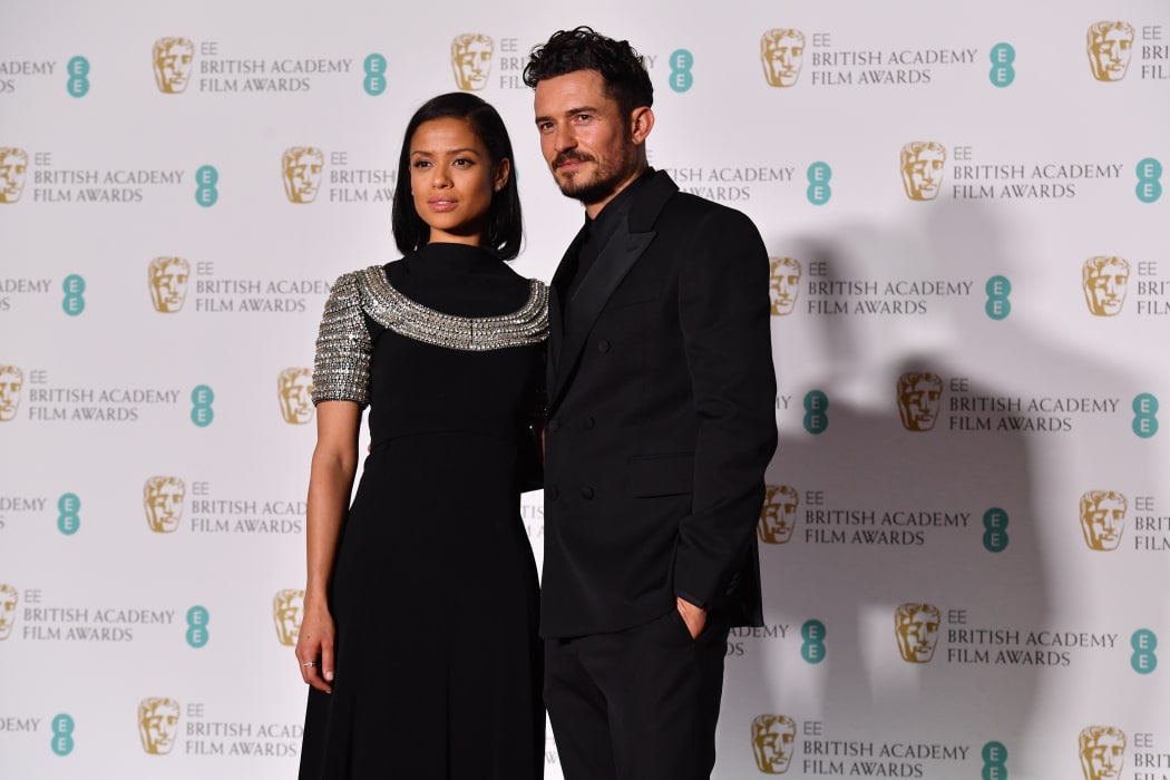 British actor Orlando Bloom (R) and British actress Gugu Mbatha-Raw pose in the press room after presenting an award.