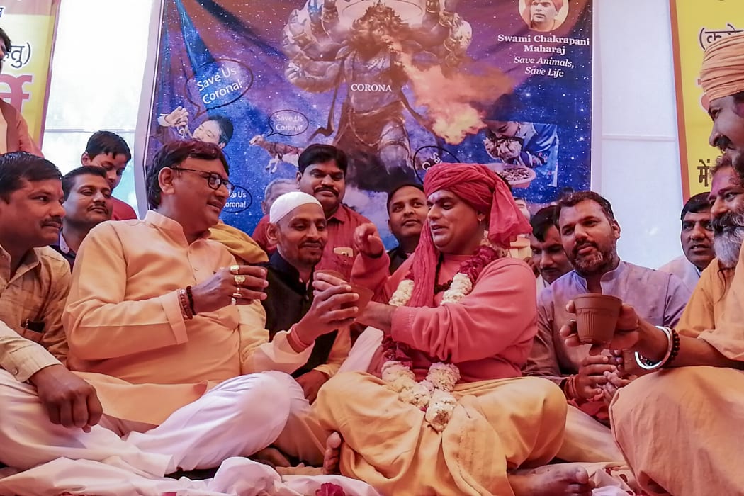 Hindu organisation 'Akhil Bharat Hindu Mahasabha' president Chakrapani Maharaj (centre right) drinks with other members and supporters a mixture made of cow dung, urine, milk, curd and ghee said to fight the spread of Covid-19, in March 2020.