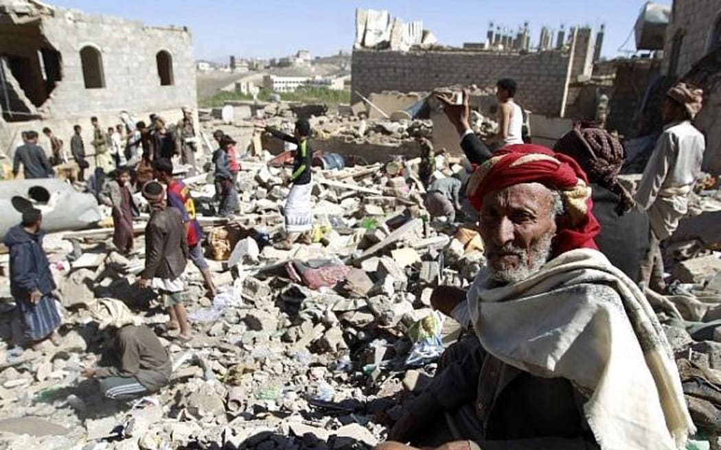 A Yemeni man sits on the rubble as people search for survivors in houses destroyed by a Saudi-led air strike on a residential area in Yemen's capital,