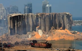 The damaged grain silo and a burnt boat at Beirut's harbour a day after powerful twin explosions tore through Lebanon's capital from the ignition of a huge depot of ammonium nitrate at the city's main port.