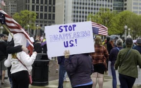 People affiliated with the 50501 movement protest the Trump Administration in downtown Detroit, Michigan on Saturday, 19 April, 2025.