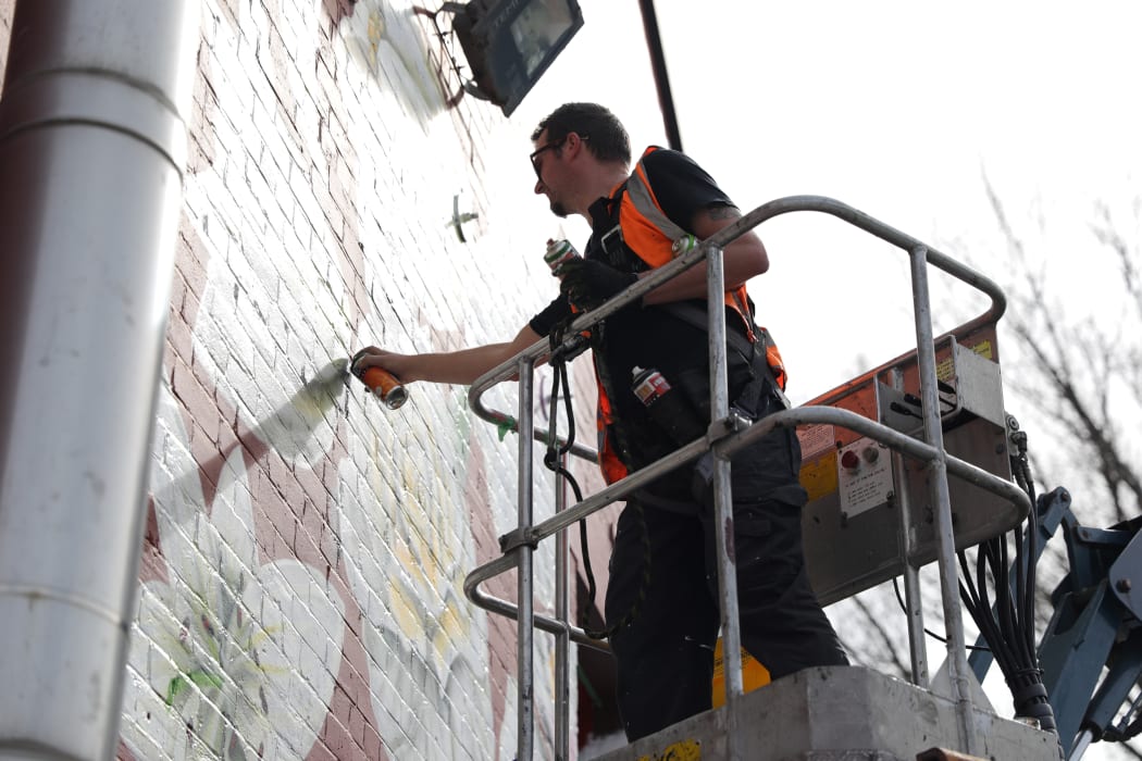 Artist Paul X Walsh has painted 51 flowers on the side of Pomeroys Inn in Christchurch as a mural for the victims of the March 15th Mosque Attack.