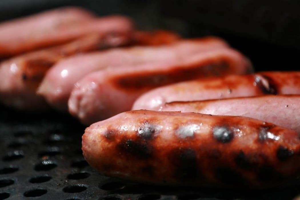 Pork sausages on a barbecue.