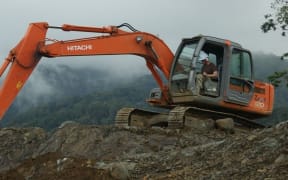 Corporal Daniel Fenton of the NZ Defence Force demonstrates the use of a digger.