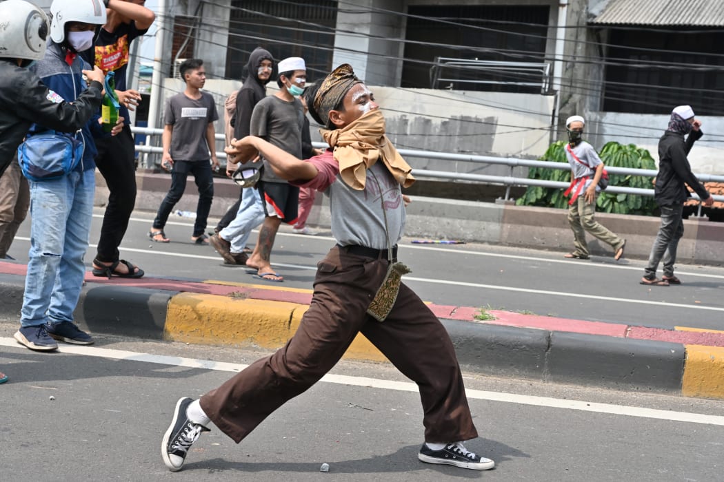 Protesters hurl rocks toward police during a clash in Jakarta.