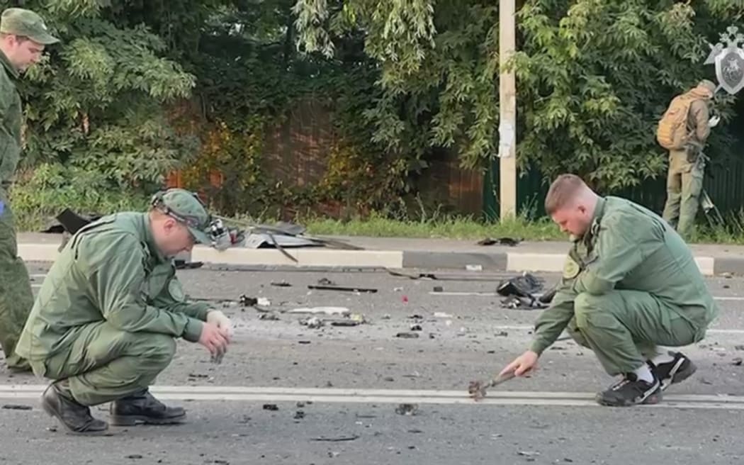 Russian officials investigate the scene after the car of Darya Dugina, daughter of Alexander Dugin, Russian political scientist and ally of President Vladimir Putin exploded on Mozhayskoye highway in Moscow, Russia on 21 August 2022.