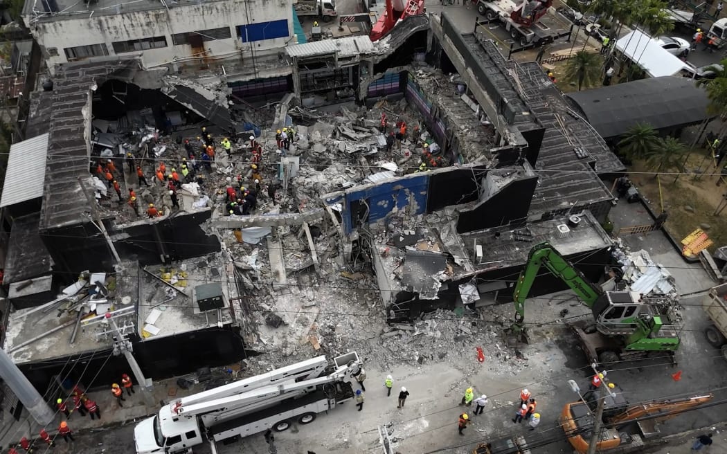 AThis aerial view shows rescue teams working at the Jet Set nightclub a day after the collapse of its roof in Santo Domingo on April 9, 2025. Rescuers raced to find survivors among the rubble of the nightclub where at least 124 people, including a former Major League Baseball star, were killed when the roof collapsed. (Photo by Alfred DAVIES / AFP)