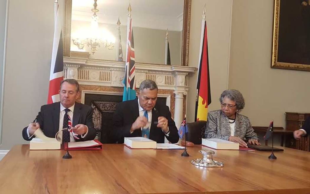The British international trade secretary, Liam Fox, with Jitoko Tikolevu and Winnie Kiap, the high commissioners to the UK for Fiji and Papua New Guinea, signing a post-Brexit trade deal, 14 March 2019.