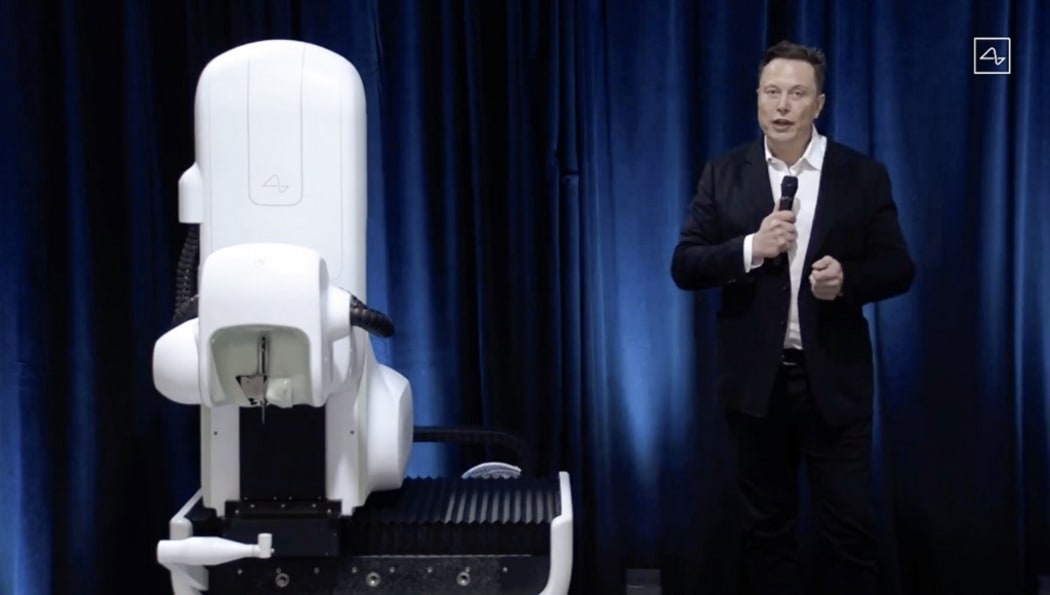 Elon Musk standing next to a surgical robot during his Neuralink presentation on August 28, 2020.
