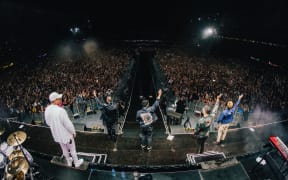 Six60 waving to fans from the stage at Eden Park.
