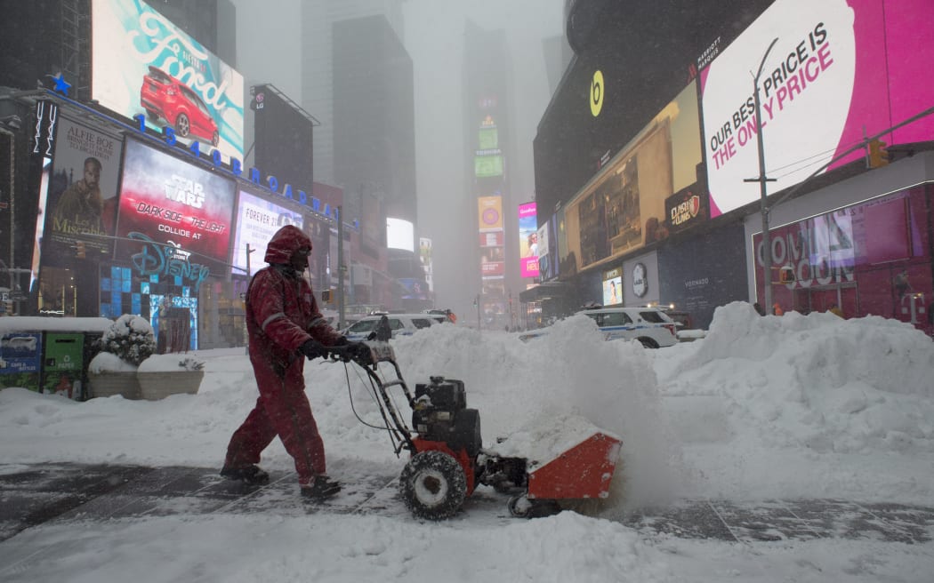 A worker clears snow from pavement in Times Square, New York City.