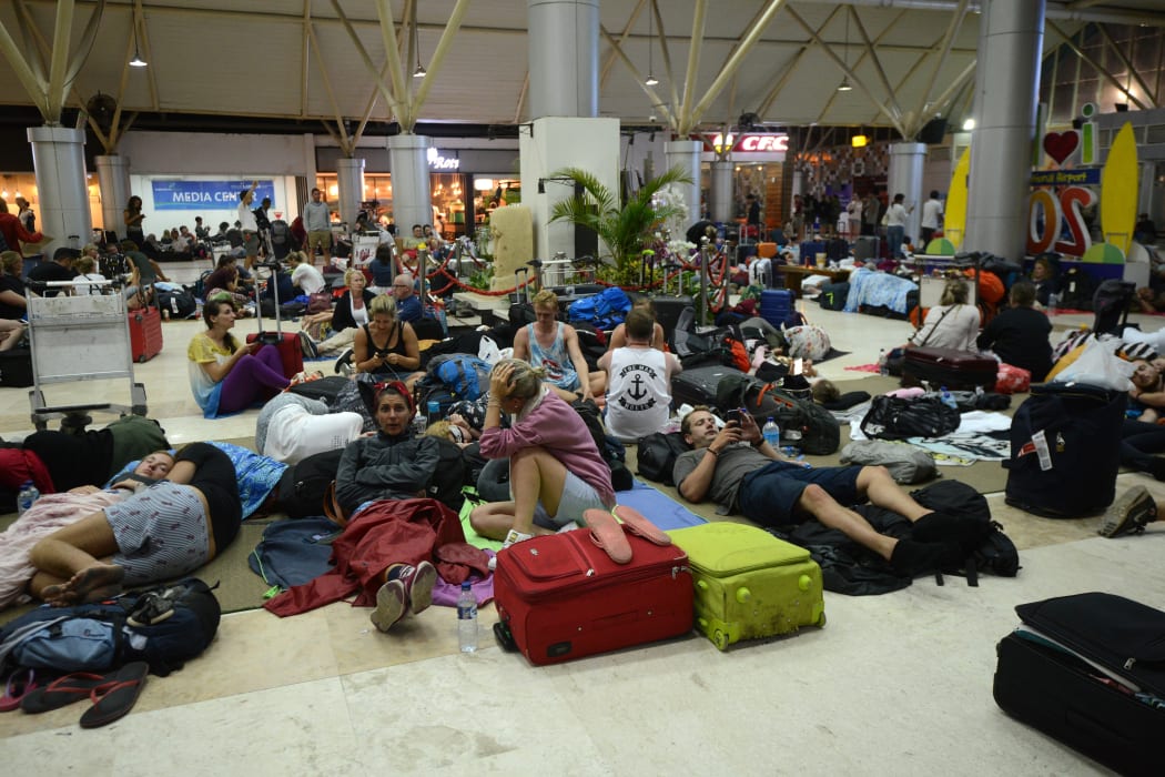 Foreign tourists sleep on the floor as they wait to depart from the Praya Lombok International Airport as aftershocks continue to rock Indonesia.