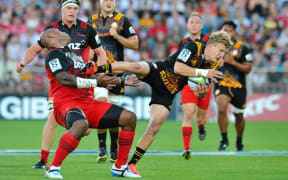 Crusaders wing Nemani Nadolo cops a face full of Chiefs fullback Damian McKenzie's boot.