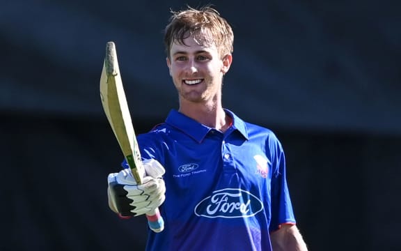 Cole Briggs celebrates his century on first-class debut for Auckland.