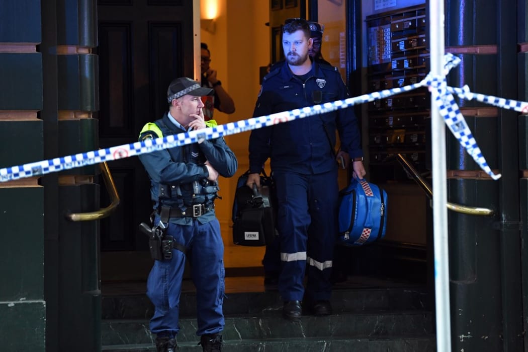 Police investigate inside a building near the scene of a knife rampage in Sydney.