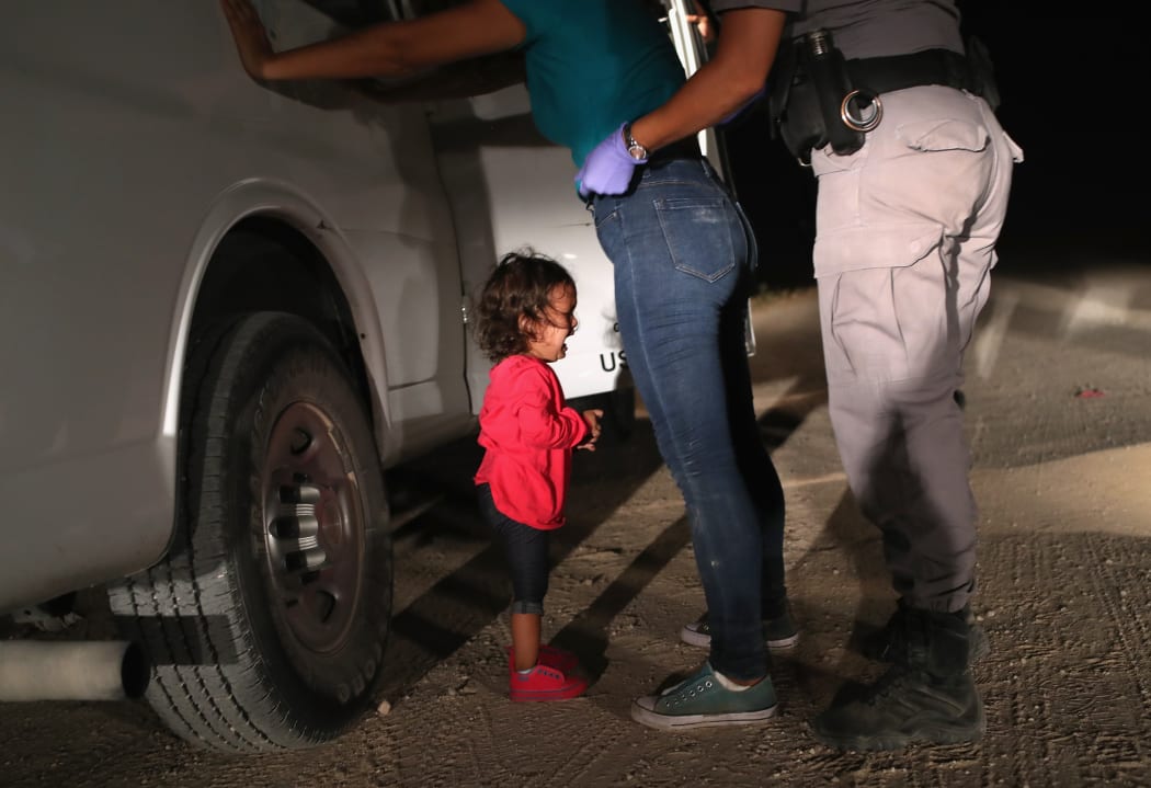 (FILES) In this file photo taken on June 11, 2018 a two-year-old Honduran asylum seeker cries as her mother is searched and detained near the U.S.-Mexico border in McAllen, Texas.