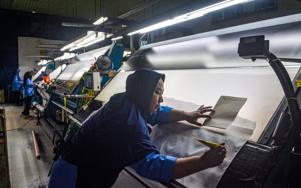 A worker inspects fabric for export before the dyeing process at the Trisula Textile Industries factory in Cimahi, West Java on 15 April, 2025.