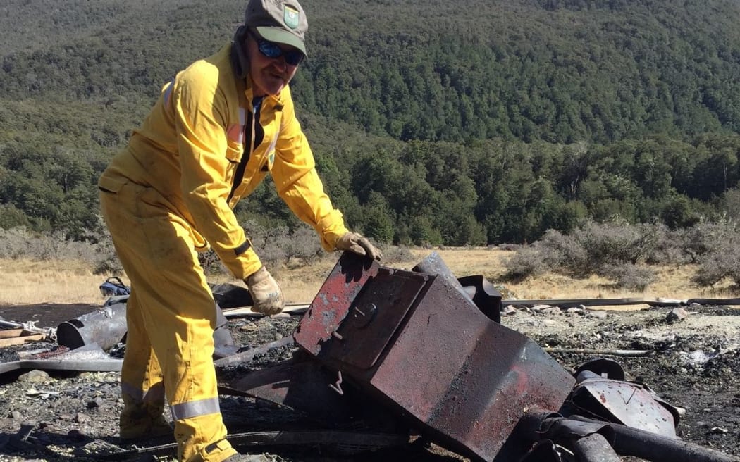DoC Fire staff Brian Taylor with the remains of the hut stove.
