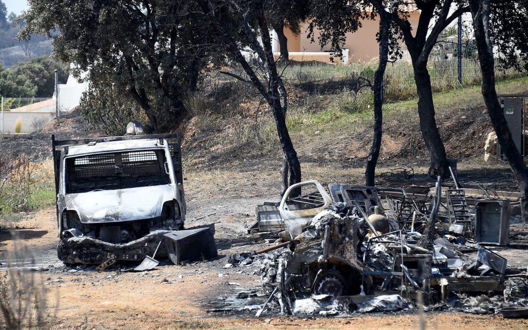This picture taken on June 29, 2019 shows a burnt van and debris after a brushfire hit the countryside around Saint Gilles, in the south of France.
