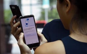 Government Technology Agency (GovTech) staff demonstrate Singapore's new contact-tracing smarthphone app called TraceTogether, as a preventive measure against the COVID-19 coronavirus in Singapore .