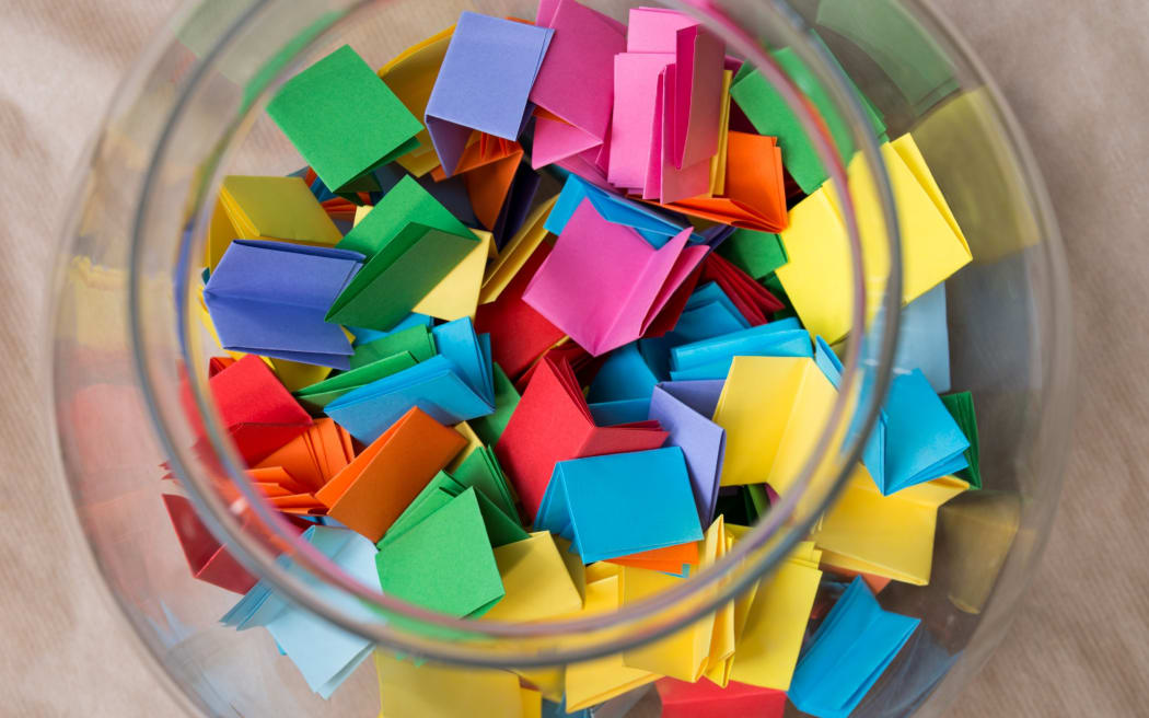 Stock photo, notelets in a jar - to 'draw a name from the hat'