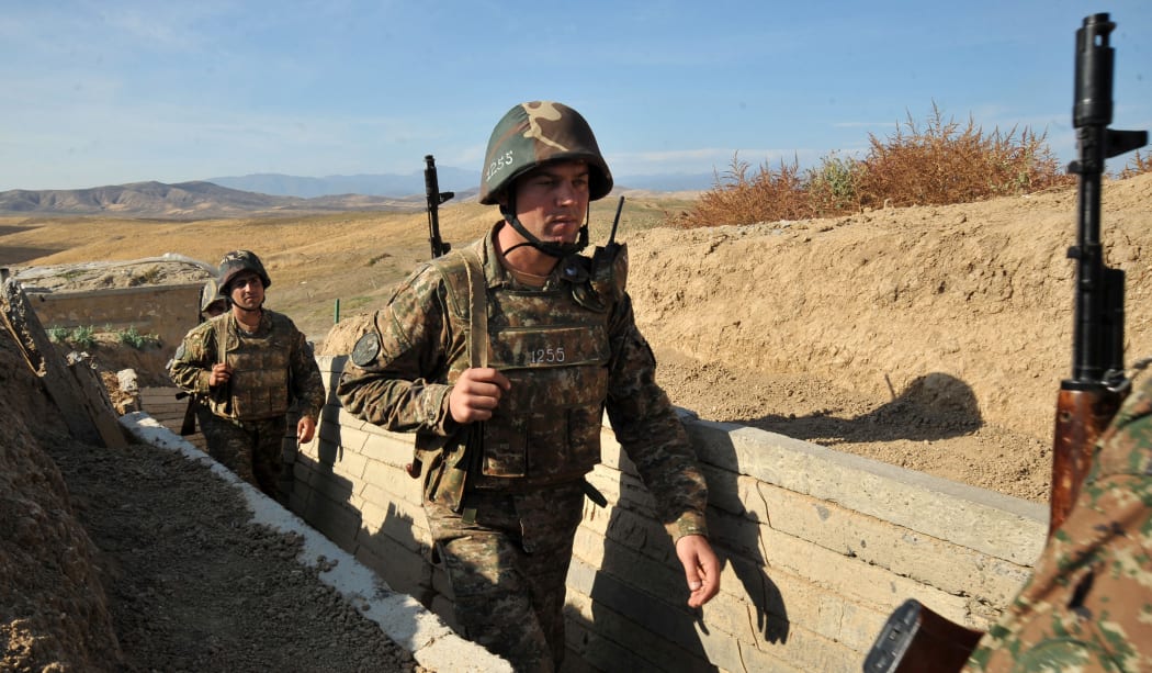A file photo taken in October 2012 shows Armenian soldiers of Nagorno-Karabakh walking in trenches at the frontline on the border with Azerbaijan.