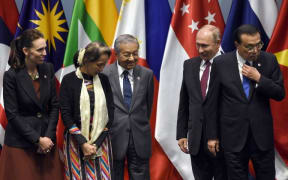 Prime Minister Jacinda Ardern, Myanmar State Counsellor Aung San Suu Kyi, Malaysia's Prime Minister Mahathir Mohamad, Russian President Vladimir Putin and Chinese Premier Li Keqiang arrive on stage to pose for a group photo with other leaders.