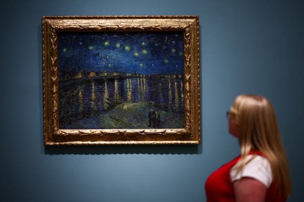 A visitor looks at a painting made by late Dutch artist Vincent Van Gogh "Starry Night over the Rhone" 1888, during a press preview for "Van Gogh: Poets and Lovers" exhibition at the National Gallery, in London, on September 9, 2024.