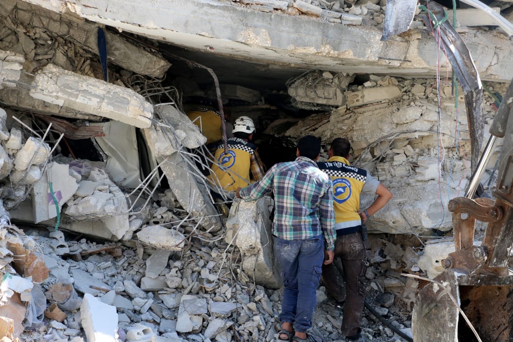 Syrian civil defense members conduct search and rescue operations at wreckage of a building after a blast in Idlib, Syria.