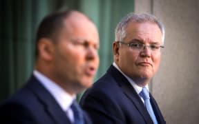 Australian Prime Minister Scott Morrison (R) reacts as he stands with the Australian Treasurer Josh Frydenberg