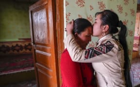 Buzeynep Abulehet,the eldest daughter of a family of six, kisses her mother before leaving for work, at her home in Moyu of Hotan Prefecture, northwest China's Xinjiang Uygur Autonomous Region, March 26, 2020.