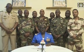 This video frame grab image obtained by AFP from ORTN - Télé Sahel on 26 July, 2023 shows Colonel Major Amadou Abdramane (C), spokesperson for the National Committee for the Salvation of the People (CNSP) speaking during a televised statement.
