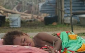 A child sleeps outside the New Covenant Church in Sangava Village
