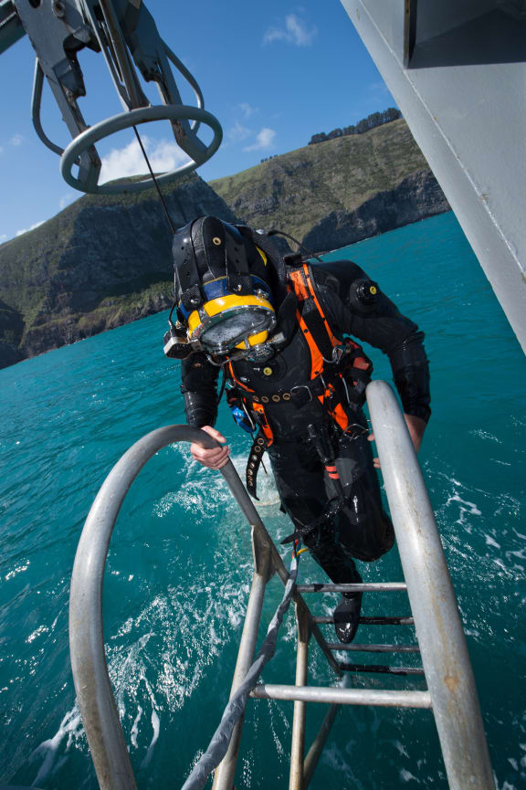 Navy diver Luke Gordon climbs back on board HMNZS Manawanui during preparation for a search and recovery operation at the site of the sunken FV Jubilee on 26 October 2015.