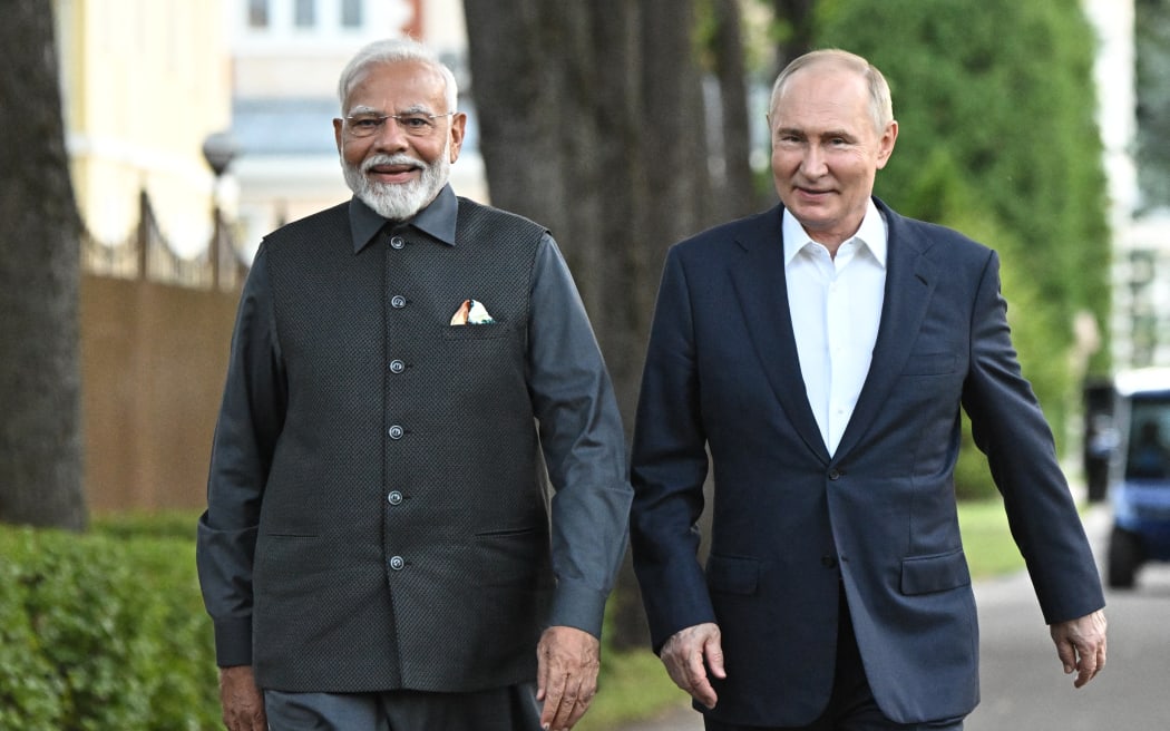 In this pool photograph distributed by the Russian state agency Sputnik, Russia's President Vladimir Putin and Indian Prime Minister Narendra Modi take a walk during an informal meeting at the Novo-Ogaryovo state residence, outside Moscow, on July 8, 2024. (Photo by Sergei BOBYLYOV / POOL / AFP)