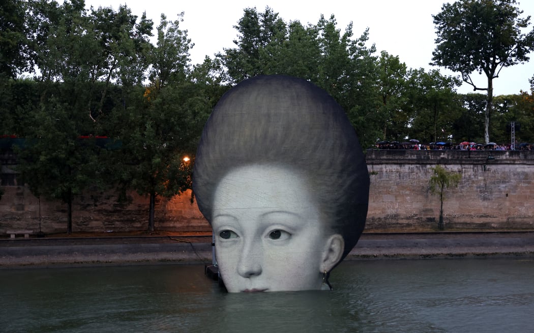 PARIS, FRANCE - JULY 26: A cutout of a face is seen in the River Seine during the opening ceremony of the Olympic Games Paris 2024 on July 26, 2024 in Paris, France. (Photo by Hannah Peters / POOL / AFP)