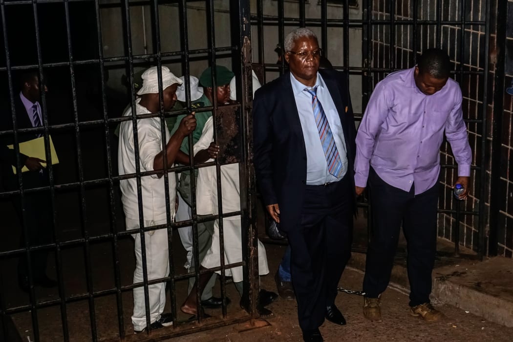 Zimbabwe's former Minister of Finance Ignatius Chombo (second right) leaves Harare Magistrate Court