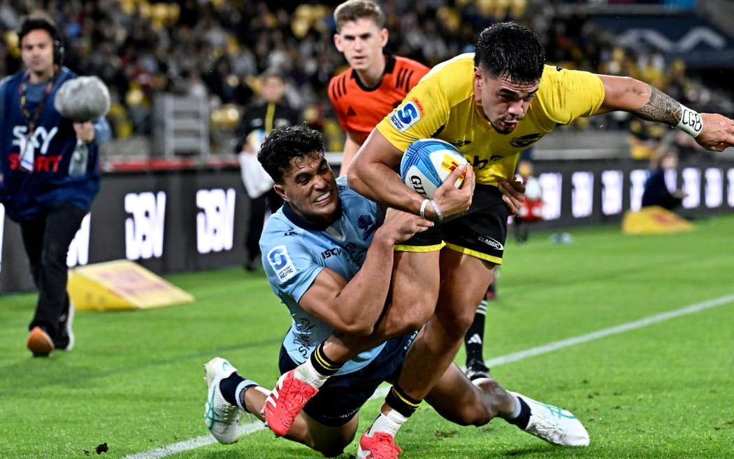 Ngatungane Punivai of the Hurricanes is tackled by Joseph-Aukuso Suaalii of the Waratahs.