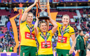 Australia's Kezie Apps, Sammy Bremner & Ali Brigginshaw lift the Women's Rugby League World Cup Trophy after victory over New Zealand. 2022.