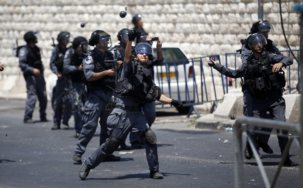 JERUSALEM : Israeli police throw stun grenades toward Palestinians during clashes after the Friday prayer outside of the Old City in East Jerusalem on July 4, on the first Friday of the holy fasting month of Ramadan. Israel closed access to the Al-Aqsa Mosque to Palestinian men under the age of 50.