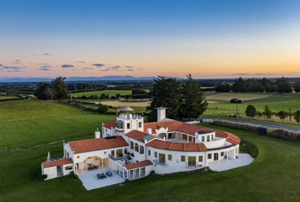 Drone shot from above showing the whole European styled property with white walls and a terracotta roof