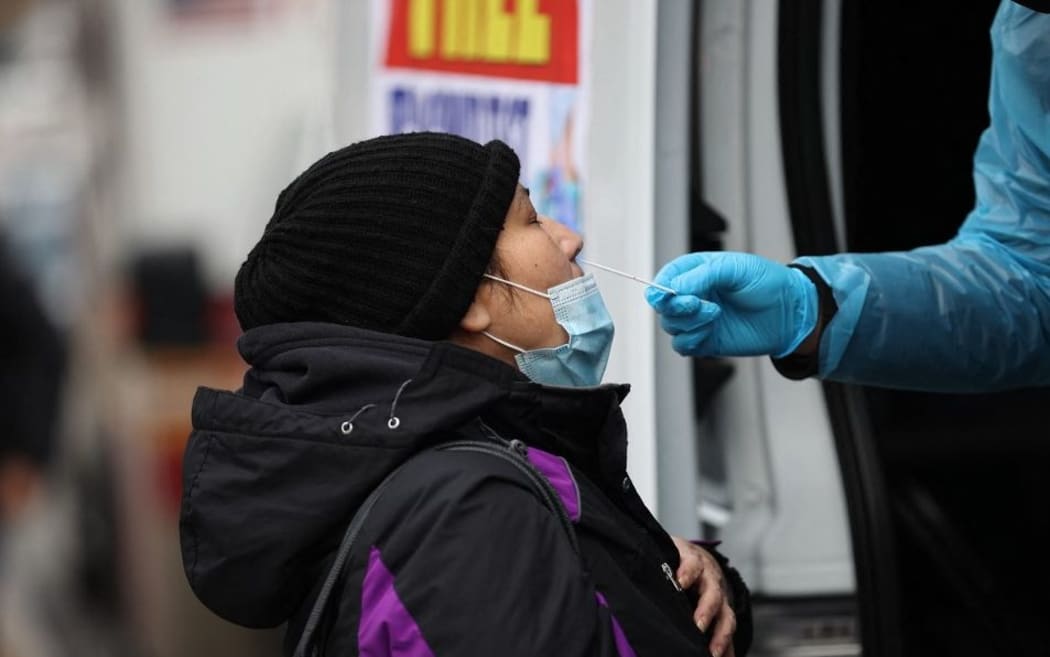 NEW YORK, USA - DECEMBER 28: A woman is getting a Covid-19 test at a Covid-19 testing center next to the Queens Hospital Center as hundreds of residents line up to get Covid-19 test in Queens of New York, United States on December 28, 2021 as Omicron rises around the country.