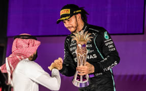 Lewis Hamilton is presented with his trophy after winning the 2021 Saudi Arabia Formula One Grand Prix.