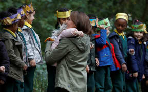 Britain's Catherine, Duchess of Cambridge (R), receives a hug from four-year-old Amwaar, as she says goodbye to school children after visiting to Sayers Croft Forest School and Wildlife Garden in London.