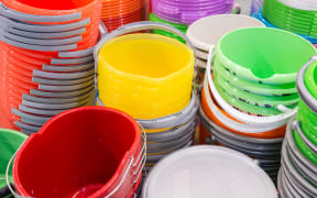 A stack of plastic bucket of different colours.