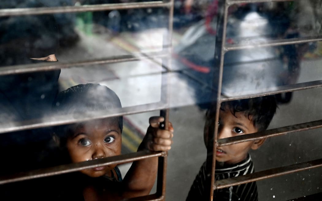 Women take shelter with their children in Shahpori island on the outskirts of Teknaf, on May 14, 2023, ahead of Cyclone Mocha's landfall. Thousands fled Myanmar's west coast and officials in neighbouring Bangladesh raced to evacuate Rohingya refugees on May 13 as the most powerful cyclone in the region for over a decade churned across the Bay of Bengal. (Photo by Munir uz zaman / AFP)