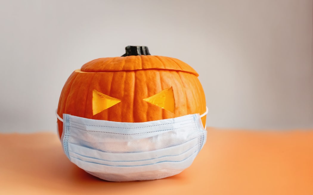 Orange pumpkin in a protective medical mask, Halloween during covid-19 pandemic times. New normal, year 2020 concept