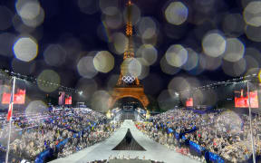 Overview of the Trocadero venue, with the Eiffel Tower looming in the background and raindrops speckling the camera lens, at the arrival of delegations during the opening ceremony of the Paris 2024 Olympic Games on July 26, 2024 (Photo by François-Xavier MARIT / AFP)