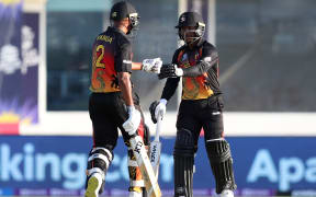 Papua New Guinea's Sese Bau (R) bumps his fist with teammate Norman Vanua during their T20 World Cup clash against Scotland.