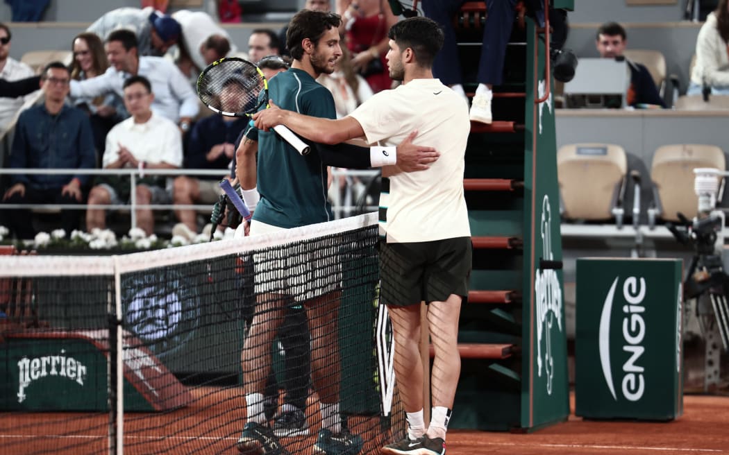 Spain's Carlos Alcaraz (R) comforts Italy's Lorenzo Musetti after he withdrawn due to an injury at the end of their men's singles semi-final match on day 13 of the French Open tennis tournament on Court Philippe-Chatrier at the Roland-Garros Complex in Paris on June 6, 2025. (Photo by Thibaud MORITZ / AFP)